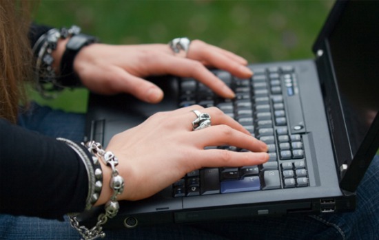 woman's hand with punkish jewelry on computer keyboard